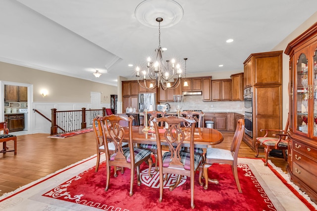 dining area featuring an inviting chandelier, ornamental molding, and light hardwood / wood-style floors