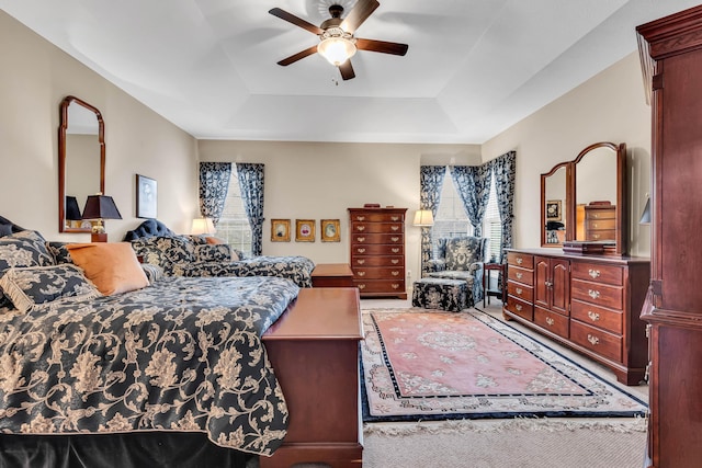 bedroom with a raised ceiling and ceiling fan