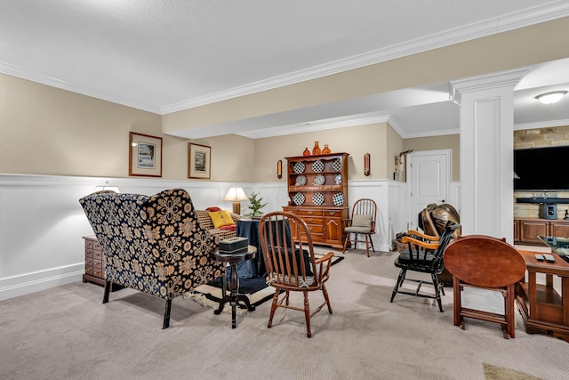 sitting room featuring light carpet, crown molding, and decorative columns