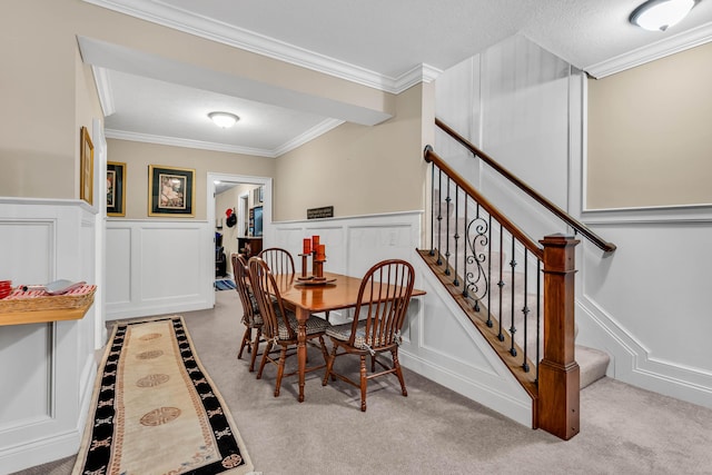 dining area with crown molding and light colored carpet