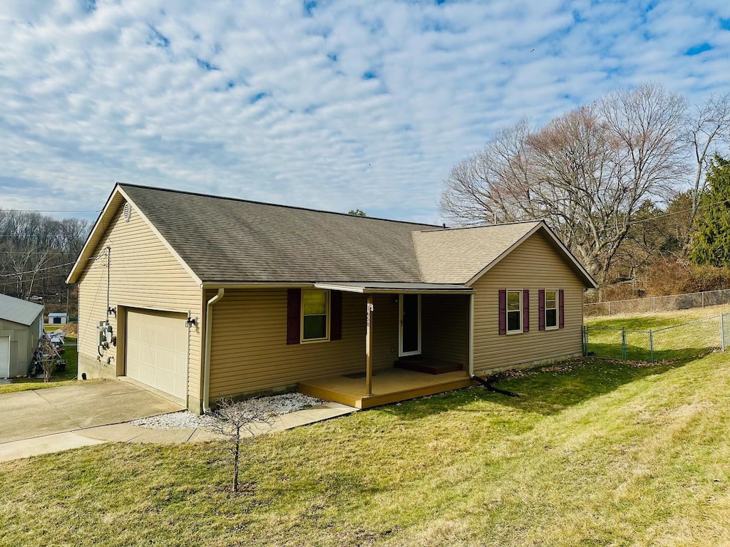 view of front of home with a garage, covered porch, and a front yard