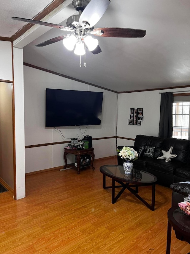 living room with vaulted ceiling, ornamental molding, ceiling fan, and light hardwood / wood-style flooring