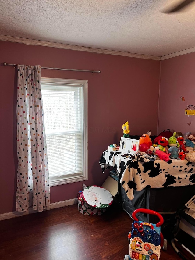 bedroom featuring crown molding, dark wood-type flooring, and a textured ceiling