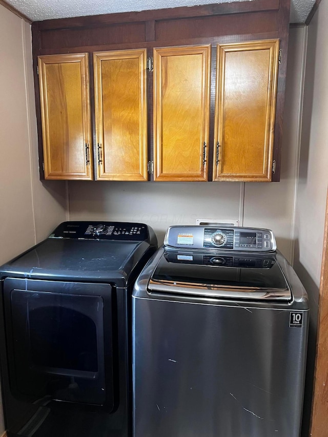 washroom with independent washer and dryer and cabinets