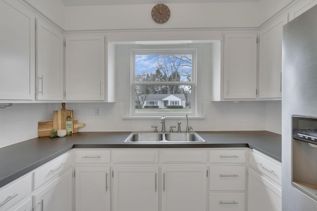 kitchen with tasteful backsplash, white cabinetry, sink, and stainless steel fridge with ice dispenser