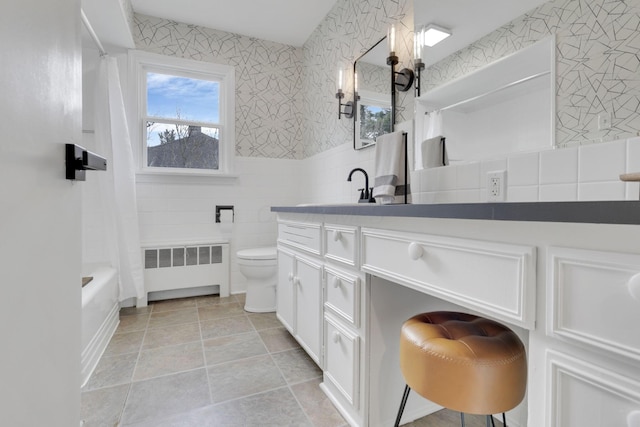 full bathroom featuring toilet, tile walls, radiator heating unit, shower / bathtub combination with curtain, and vanity