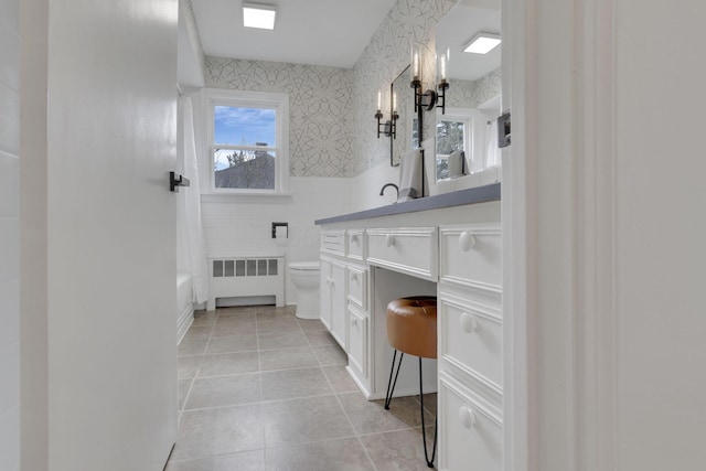 full bathroom featuring radiator, tile walls, vanity, toilet, and tile patterned floors