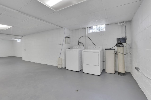 basement with a paneled ceiling and separate washer and dryer