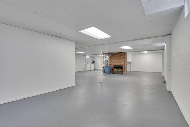 basement with a drop ceiling and a fireplace