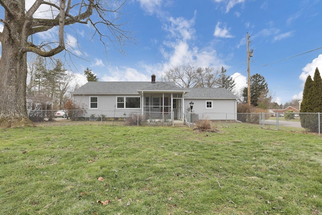 back of property with a lawn and a sunroom