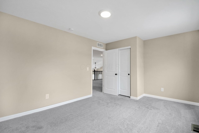 unfurnished bedroom featuring light colored carpet and a closet