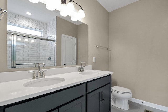 bathroom featuring tile patterned flooring, vanity, an enclosed shower, and toilet