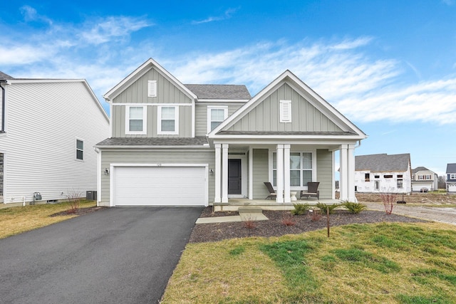 view of front of house featuring a garage, a porch, and a front lawn