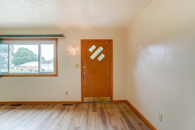 entrance foyer featuring light hardwood / wood-style flooring and a textured ceiling