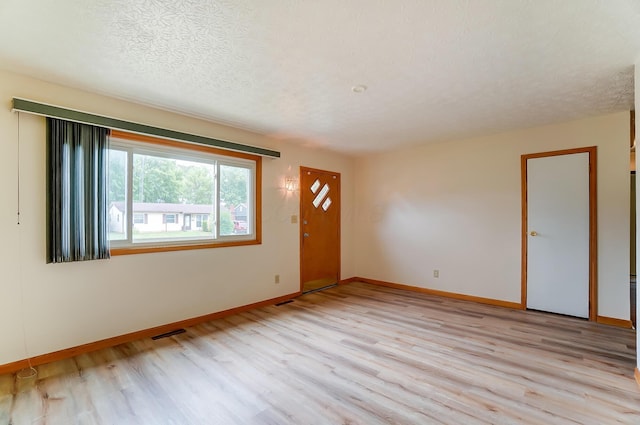 foyer with light hardwood / wood-style floors and a textured ceiling