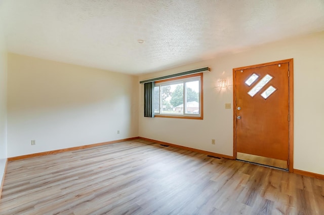 entrance foyer with a textured ceiling and light wood-type flooring