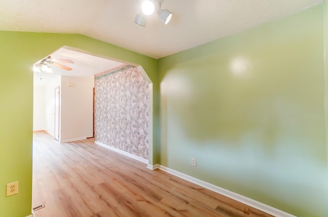 unfurnished room featuring light hardwood / wood-style flooring, ceiling fan, and vaulted ceiling