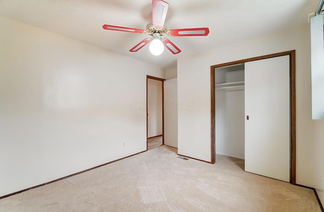 unfurnished bedroom featuring light colored carpet, a closet, and ceiling fan