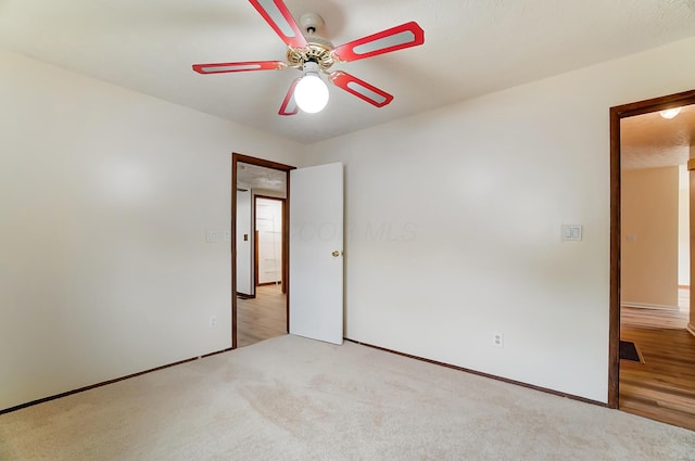 carpeted spare room featuring ceiling fan