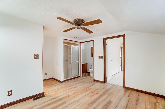 unfurnished bedroom featuring ceiling fan, ensuite bath, light hardwood / wood-style flooring, and a textured ceiling