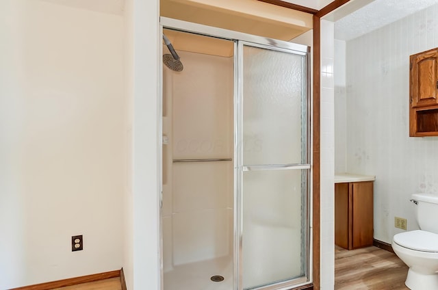 bathroom featuring wood-type flooring, toilet, and walk in shower