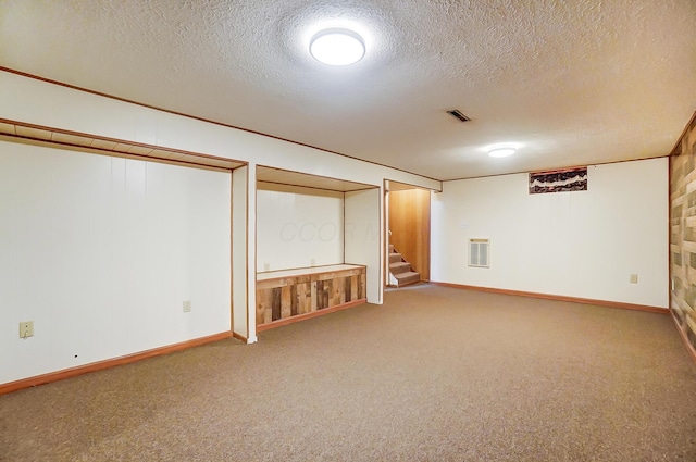 basement featuring carpet flooring and a textured ceiling