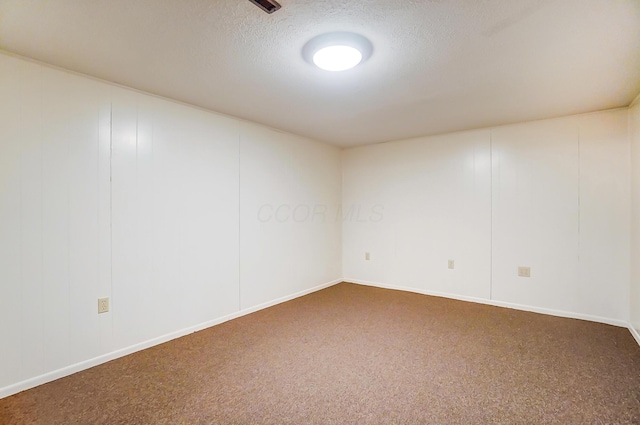 carpeted empty room featuring a textured ceiling