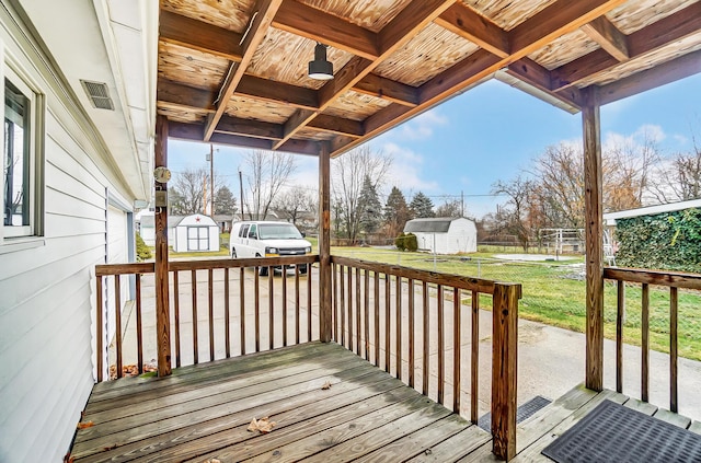 wooden deck featuring a storage shed and a yard