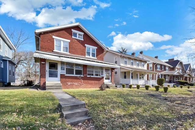 multi unit property featuring covered porch and a front yard