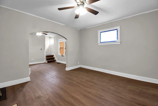 unfurnished room featuring dark wood-type flooring, ceiling fan, and crown molding