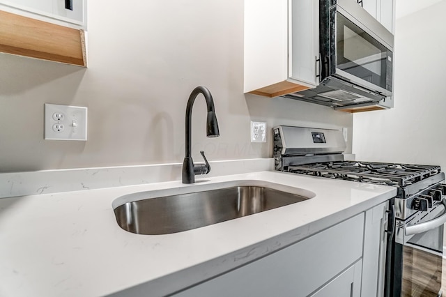 kitchen featuring white cabinetry, sink, and appliances with stainless steel finishes