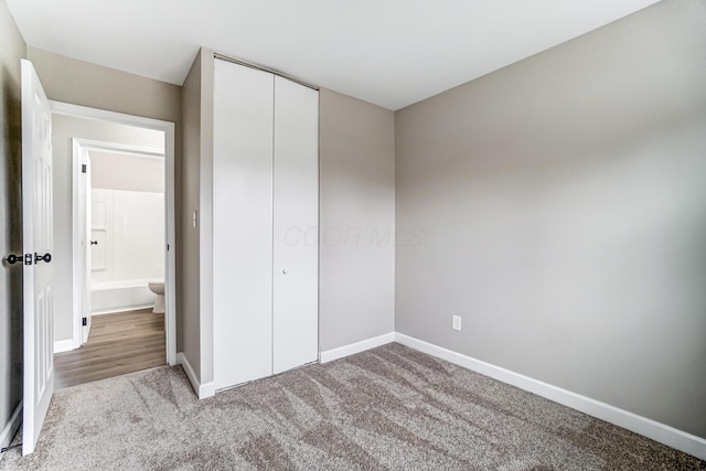 unfurnished bedroom featuring light carpet and a closet