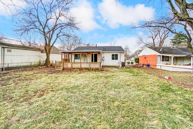 rear view of property featuring cooling unit and a yard