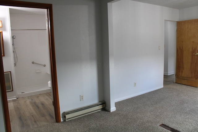 unfurnished bedroom featuring a baseboard radiator, carpet flooring, and baseboards