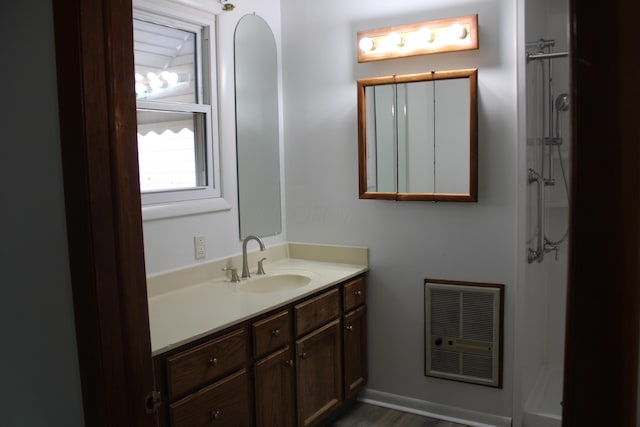 full bath with a shower, vanity, and heating unit