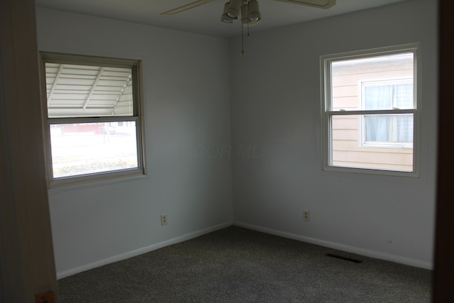 spare room featuring a ceiling fan, carpet, visible vents, and baseboards