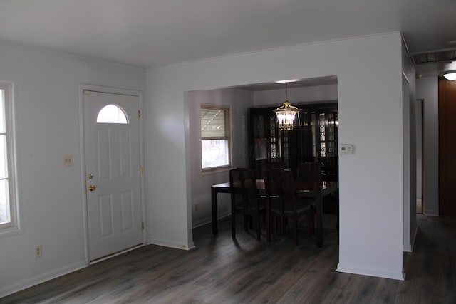 entrance foyer featuring crown molding, baseboards, a notable chandelier, and wood finished floors