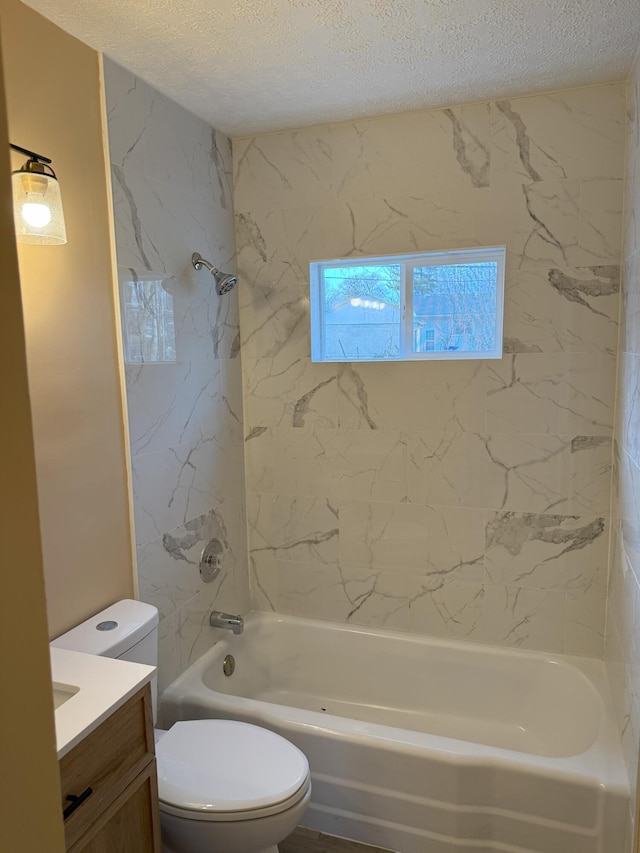 full bathroom featuring vanity, tiled shower / bath, a textured ceiling, and toilet