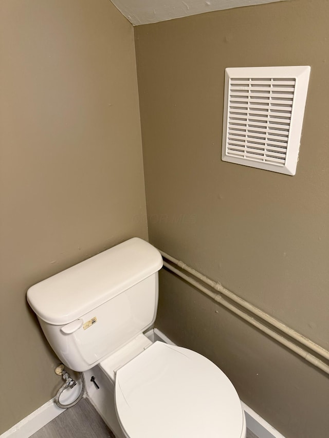 bathroom with wood-type flooring and toilet