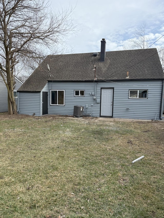 back of house featuring central AC and a lawn