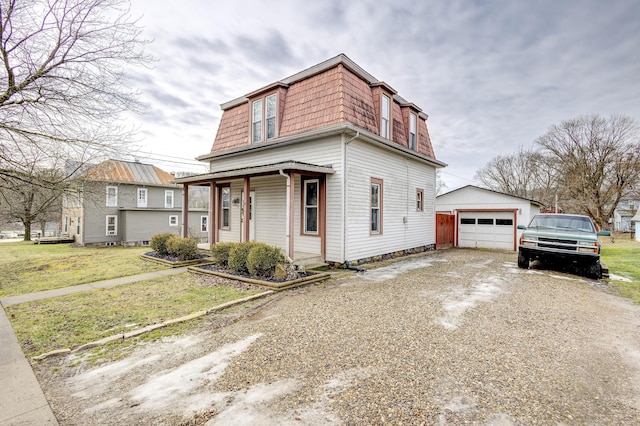 view of front of property with a garage, an outdoor structure, covered porch, and a front lawn