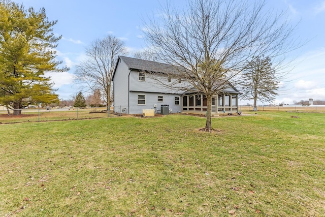 back of house featuring a yard, a sunroom, and central air condition unit