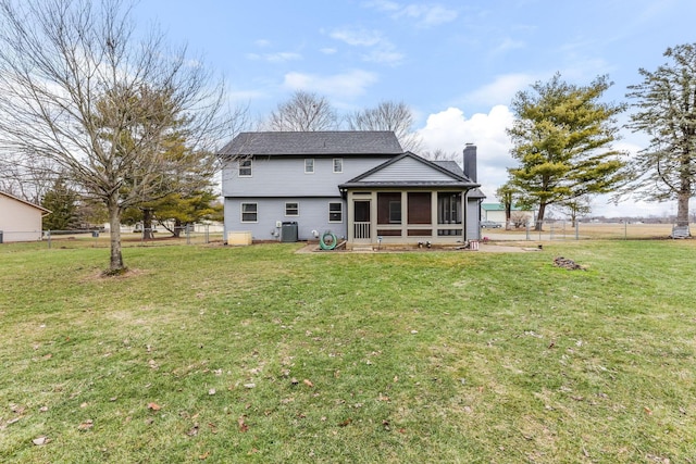 back of property featuring a sunroom, central AC unit, and a lawn