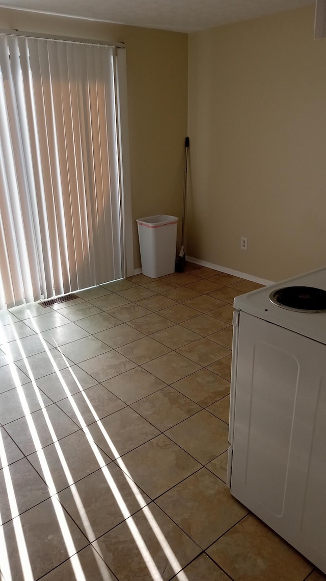 laundry area with light tile patterned floors