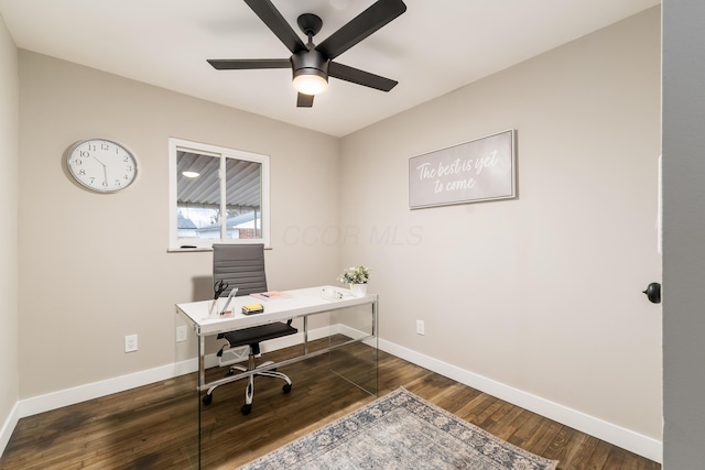 home office with ceiling fan and dark hardwood / wood-style flooring