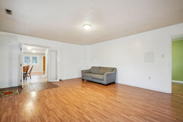 unfurnished room featuring light hardwood / wood-style flooring and a textured ceiling