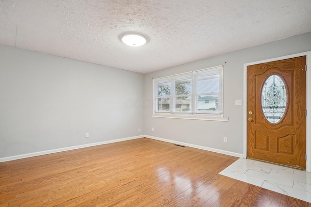 foyer featuring a textured ceiling and light wood-type flooring