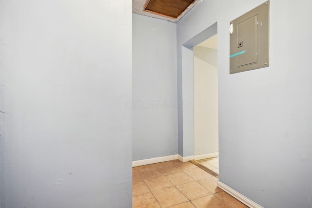 hallway featuring electric panel and light tile patterned floors