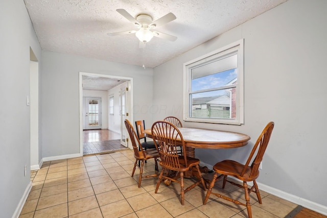 dining room featuring ceiling fan, a textured ceiling, and light tile patterned floors