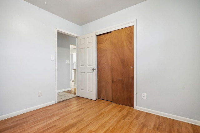 unfurnished bedroom featuring a closet and light hardwood / wood-style flooring